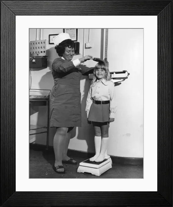 Framed Print : School nurse seen here measuring and weighing a pupil. 25th August 1972 Framed Print : School nurse seen here measuring and weighing a pupil. 25th August 1972