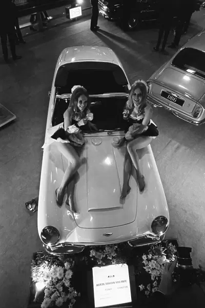 Models pose on the bonnet of a Aston Martin Volante at Motor Show 15th October 1968