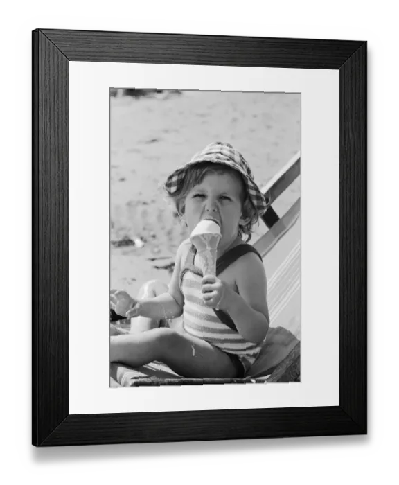 Framed Print : Eighteen month old Nicola England from Bromley, Kent enjoys an ice cream on the beach