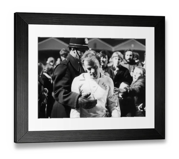 Framed Print : Leeds captain Billy Bremner leaves the field on the consoling arm of the law after his