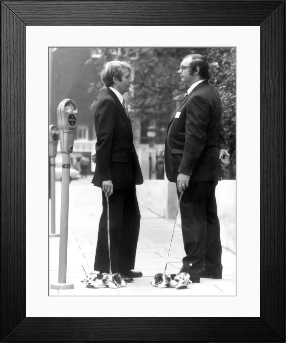 Framed Print : Wooden Snoopy Dogs on leads being demonstrated by Managing Directors of the firm that Framed Print : Wooden Snoopy Dogs on leads being demonstrated by Managing Directors of the firm that