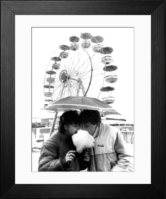 Framed Print : Couple sharing candyfloss under an unmbrella in a wet Southend. 8th April 1985