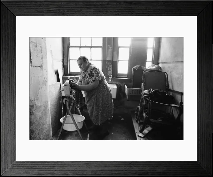 Framed Print : 71 year old Edna Clarke does her washing in the communal wash house at Great Eastern