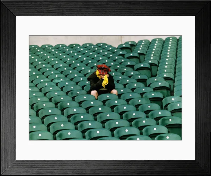 Framed Print : A dejected Scotland fan sits in a stadium with his head in his hands after his teams Framed Print : A dejected Scotland fan sits in a stadium with his head in his hands after his teams