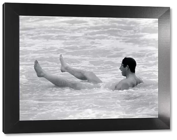 Prince Charles bathes of the coast of Australia. Prince of Wales sitting in