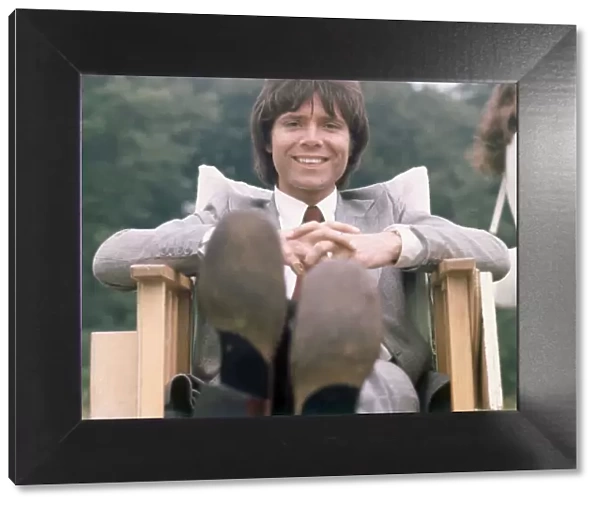 Cliff Richard seen here relaxing between takes on location filming for '
