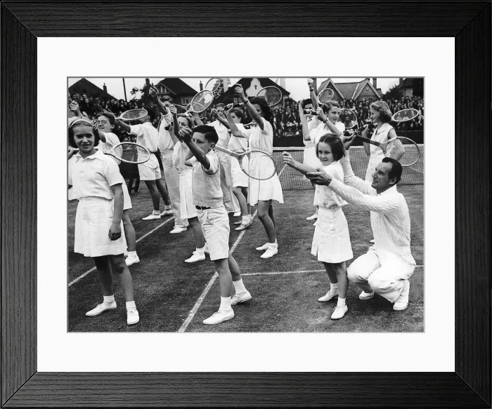 Framed Print : Fred Perry Tennis Player teaching young children how to serve a tennis ball