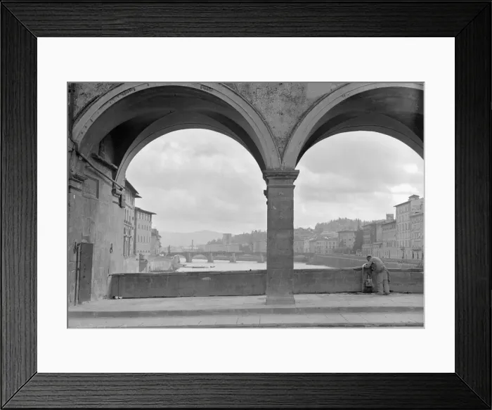 Framed Print : A workman fills his bucket from a public tap on the Ponte Vecchio bridge that spans Framed Print : A workman fills his bucket from a public tap on the Ponte Vecchio bridge that spans