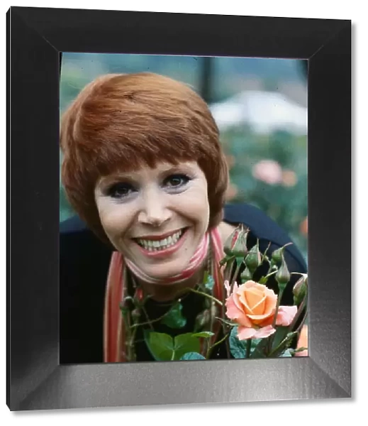 Judy Carne standing next to roses July 1979