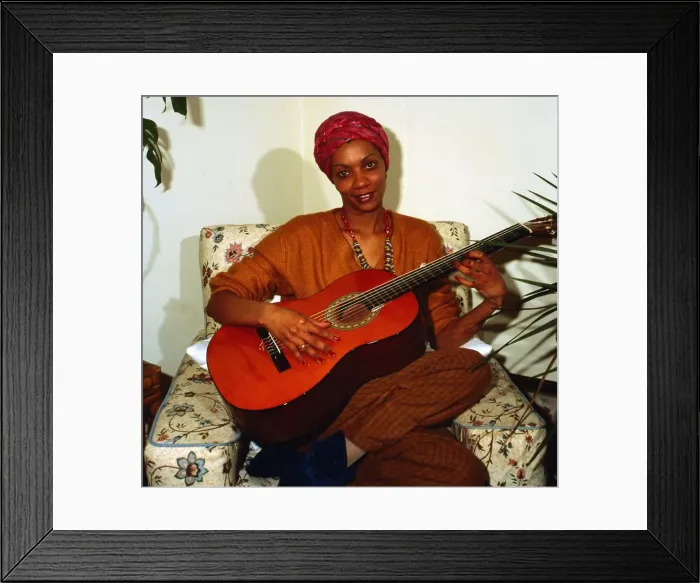 Framed Print : Eva Mottley sitting on chair playing guitar April 1983 Framed Print : Eva Mottley sitting on chair playing guitar April 1983