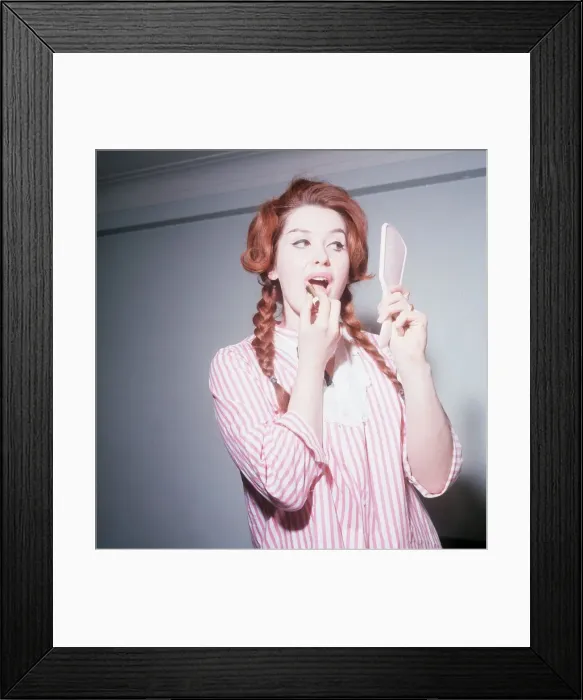 Framed Print : Heller Toren model actress 1964 puting on lipstick holding hand mirror pink striped shirt Framed Print : Heller Toren model actress 1964 puting on lipstick holding hand mirror pink striped shirt