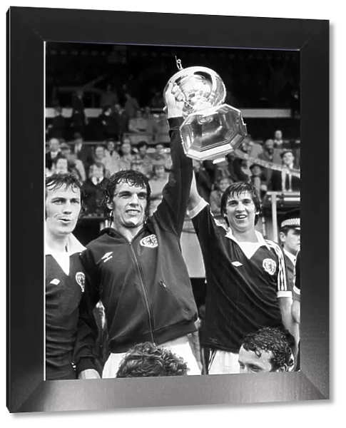 Scotland footballer Joe Jordan holds aloft the British International Football trophy with