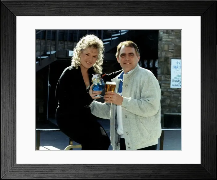Framed Print : Bill Tarmey actor with Letitia Dean actress hold glasses together