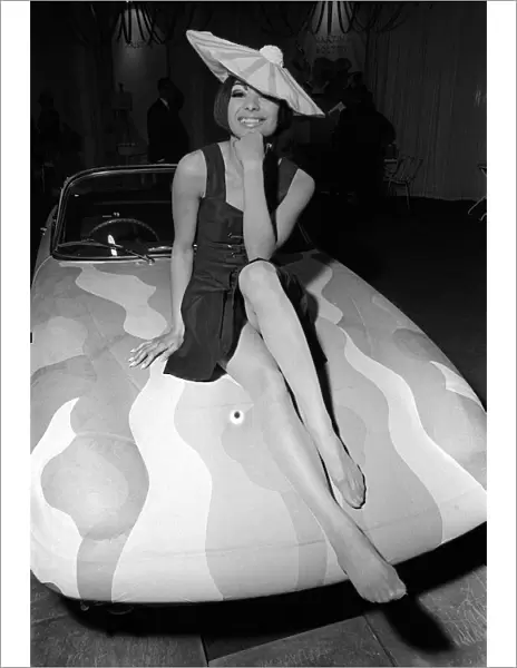 Fashion Clothing Hats April 1964 Fashion model Minerva Smith sitting on bonnet of