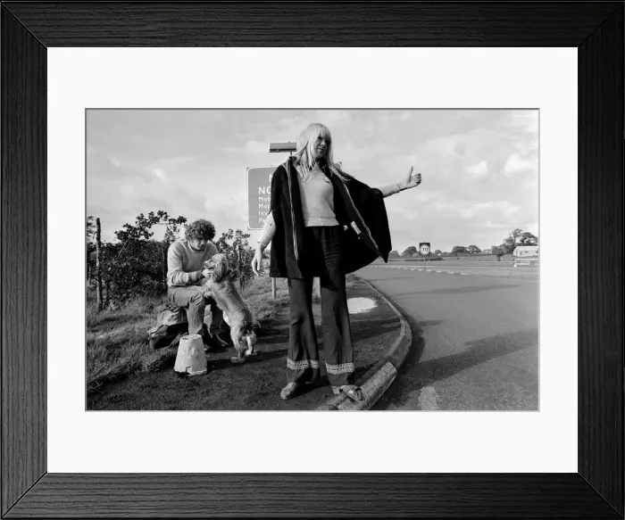 Framed Print : A young couple and their dog trying to hitch hike and get a lift on the motorway Framed Print : A young couple and their dog trying to hitch hike and get a lift on the motorway