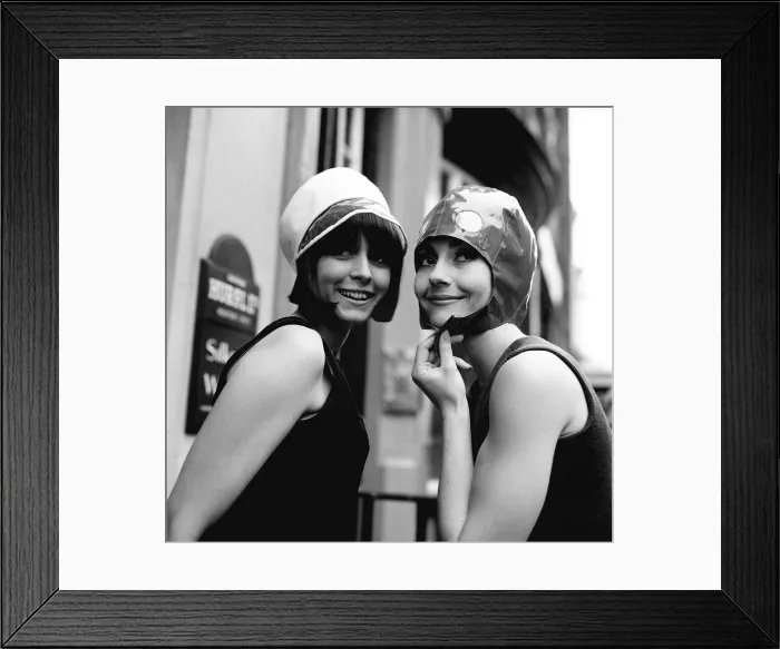 Framed Print : Two models model hats June 1965 One wears a white hat with dark trimming Framed Print : Two models model hats June 1965 One wears a white hat with dark trimming
