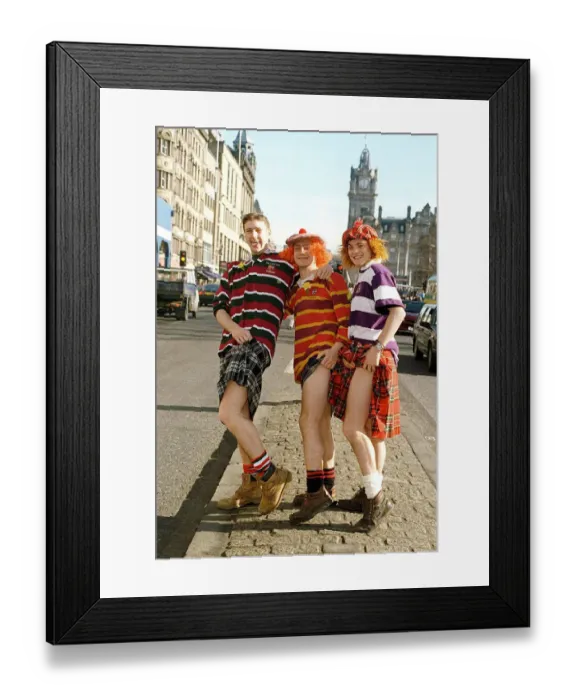 Framed Print : Scottish rugby fans wearing tartan kilts showing a leg on Princes Street Edinburgh prior