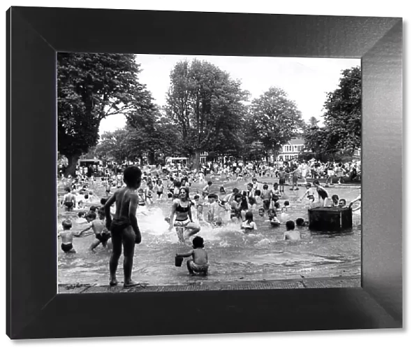 Children enjoying the sunshine having fun in the Victoria Park pool, Cardiff