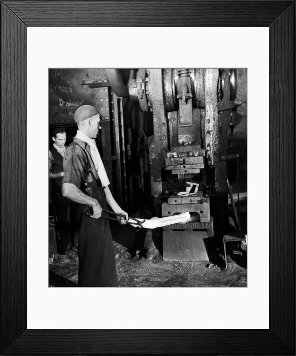 Framed Print : A worker holding his finished product, a drop-forged front axle Framed Print : A worker holding his finished product, a drop-forged front axle