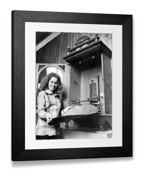 Framed Print : A young girl changes the disc on a vintage juke box or polyphone in September 1972
