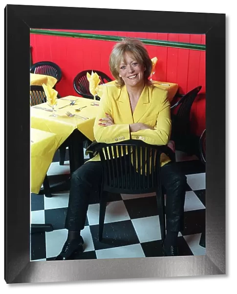 Actress Sherrie Hewson in her restaurant Booms in Richmond, sitting on a chair