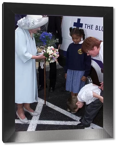 Four year old Nathan Goodwin bows to Queen Mother after presenting her with a bouquet of