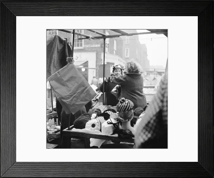 Framed Print : Women out looking for a bargain on the milliner stall at Petticoat Lane Market Framed Print : Women out looking for a bargain on the milliner stall at Petticoat Lane Market