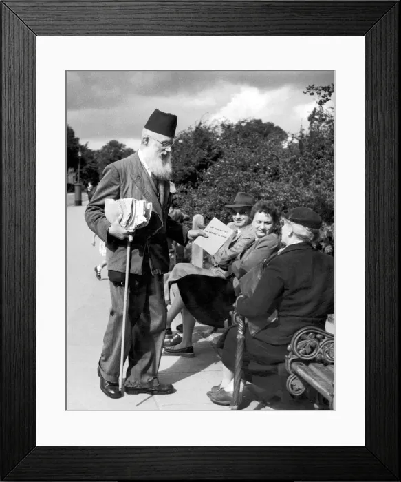 Framed Print : A salesman offering religious text to people sitting on a bench in Hampstead Heath Framed Print : A salesman offering religious text to people sitting on a bench in Hampstead Heath