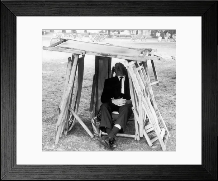 Framed Print : Man using whatever improvised materials he can find including folded up deckchairs to Framed Print : Man using whatever improvised materials he can find including folded up deckchairs to