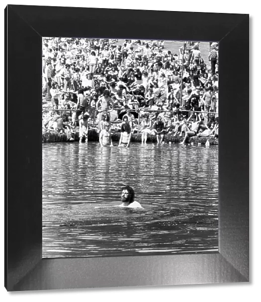 A man cools off by going for a swim in the pond in front of the stage at the Crystal