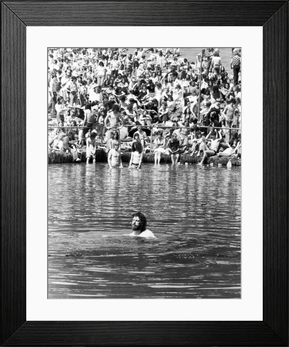 Framed Print : A man cools off by going for a swim in the pond in front of the stage at the Crystal Framed Print : A man cools off by going for a swim in the pond in front of the stage at the Crystal