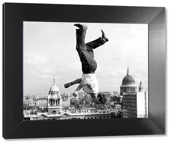 Acrobat Frank Paulo jumps upside down on a trampoline on the roof of the GPO building in