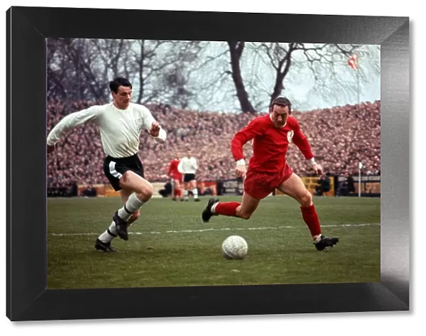 Bobby Robson of Fulham in a race for the ball with Ian St John of Liverpool during