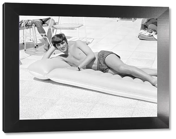 George Best Football Player Relaxing on an inflatable bed on holiday