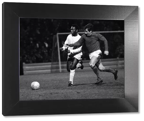 Brazilian football star Pele of Santos chases for the ball with Alan Mullery of Fulham