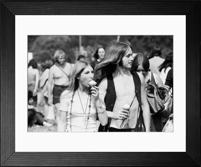 Framed Print : Reading Pop Festival. Festival goers eating ice creams as they make their way to Framed Print : Reading Pop Festival. Festival goers eating ice creams as they make their way to