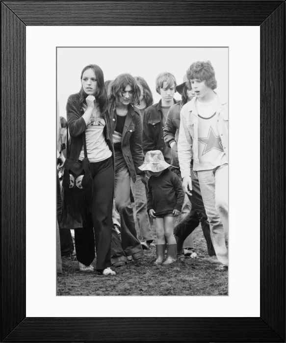 Framed Print : Reading Pop Festival. Young festival goers with small child wearing her wellington
