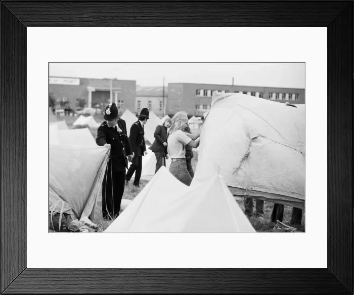 Framed Print : Reading Pop Festival. Uniformed police officers help camping pop fans to erect Framed Print : Reading Pop Festival. Uniformed police officers help camping pop fans to erect