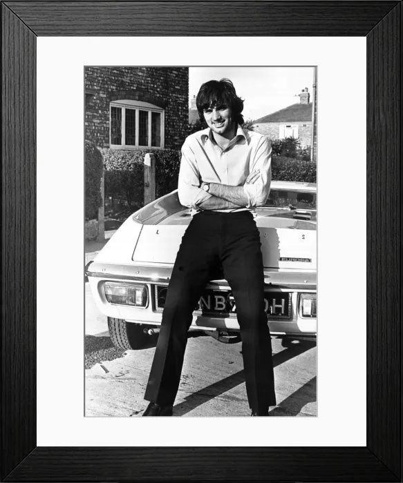 Framed Print : Footballer George Best seen here outside his Manchester home leaning against his new car
