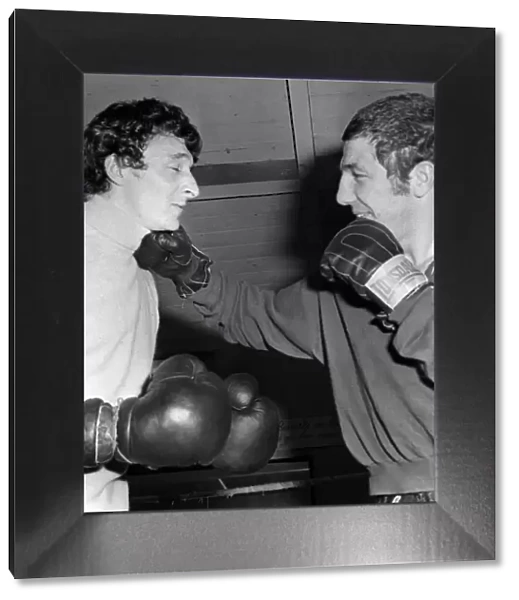 Mike Summerbee gets a right hander from heavyweight boxer Kevin Madden in the Gym where