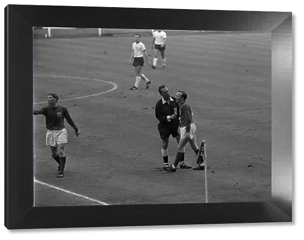 Nobby Stiles is spoken to the referee 30th July 1966. as Alan Ball makes a point