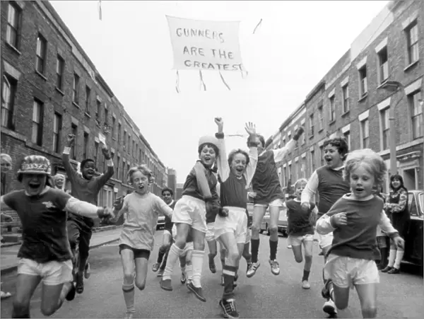 Young Arsenal fans on Blundell street, Islington, cheer for the upcoming victory against