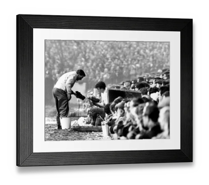 Framed Print : Leeds v. Chelsea. Billy Bremner of Leeds inspects the new boots with the trainer
