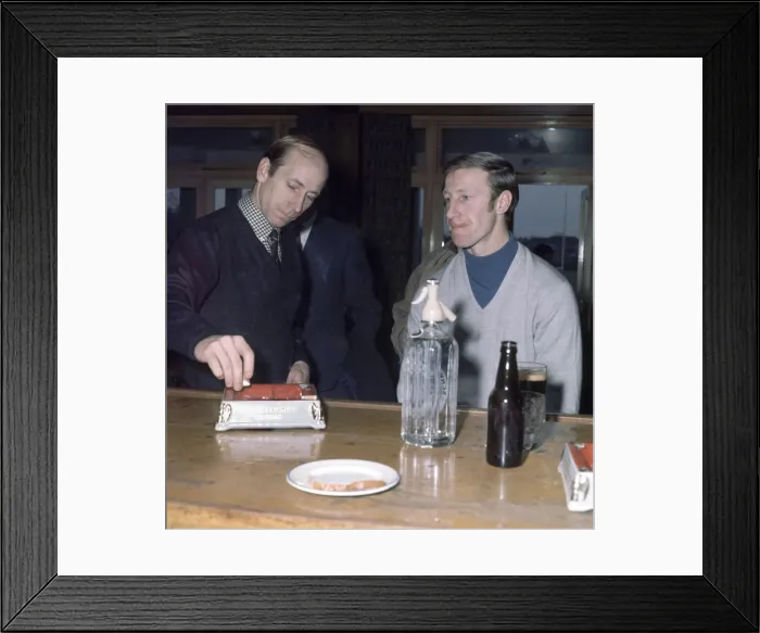 Framed Print : Manchester United footballer Bobby Charlton puts out a cigarette in the ash try as he Framed Print : Manchester United footballer Bobby Charlton puts out a cigarette in the ash try as he