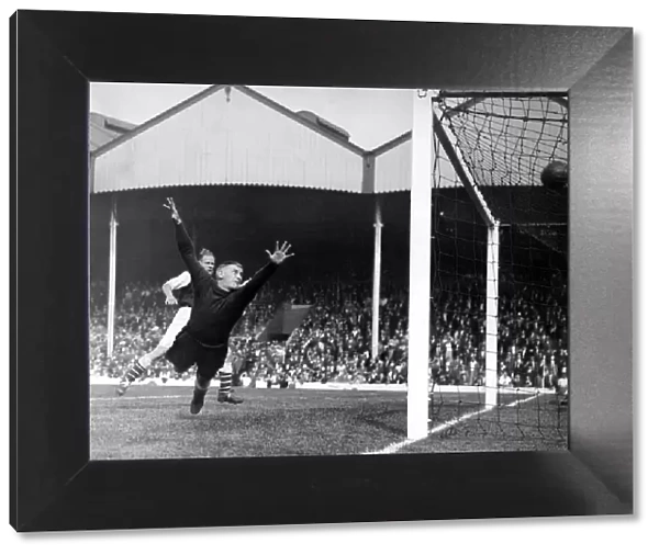 Frank Moss, football player of Arsenal FC, dives in an attempt to save a goal. c
