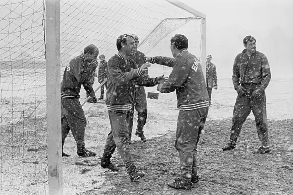 England footballer Jimmy Greaves laughs as he walks out the goal during a snow covered