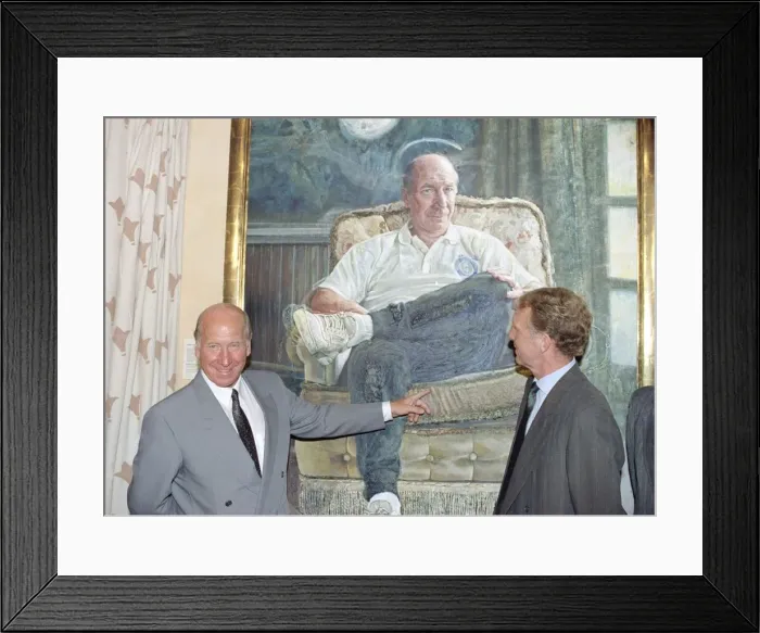 Framed Print : Manchester United director Bobby Charlton standing in front of a painting of him Framed Print : Manchester United director Bobby Charlton standing in front of a painting of him