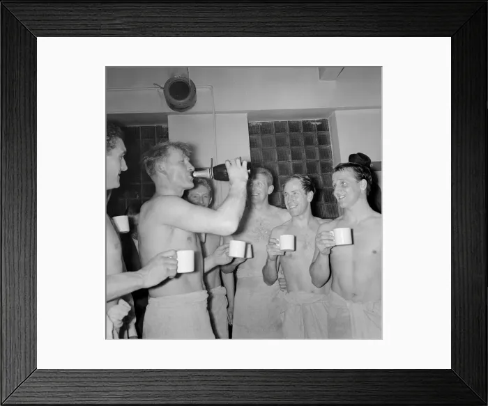 Framed Print : Bobby Charlton and others look on as Bert Trautmann drinks champagne from the bottle in Framed Print : Bobby Charlton and others look on as Bert Trautmann drinks champagne from the bottle in