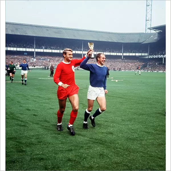 Roger Hunt football player for Liverpool and Ray Wilson of Everton run around Goodison
