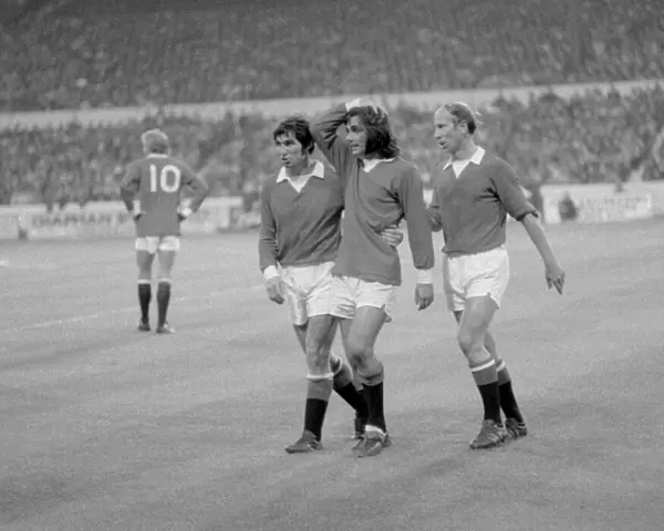 Manchester United footballer George Best is consoled by teammates Tony Dunne (left